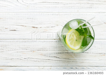 Caipirinha, Mojito cocktail, vodka or soda drink with lime, mint and straw on table background. Refreshing beverage with mint and lime in glass top view flat lay 136160493