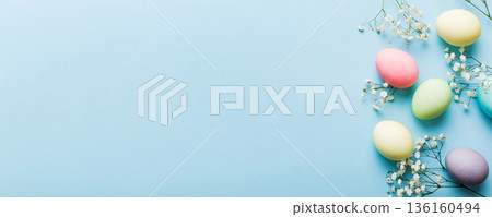 Happy Easter composition. Easter eggs on colored table with gypsophila. Natural dyed colorful eggs background top view with copy space 136160494