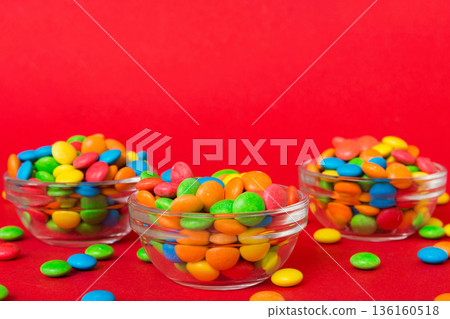 Multicolored candies in a bowl on a colored background. birthday and holiday concept. Top view with copy space Multicolored candies in a bowl on a colored background. birthday and holiday concept. Top view with copy space 136160518