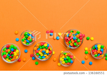 different colored round candy in bowl and jars. Top view of large variety sweets and candies with copy space 136160551