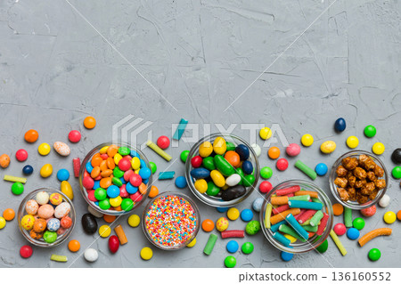 different colored round candy in bowl and jars. Top view of large variety sweets and candies with copy space 136160552