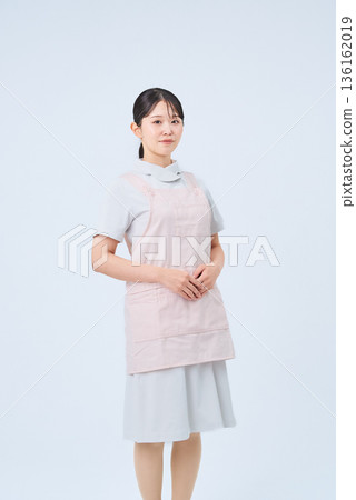 A young woman wearing a white coat and apron 136162019