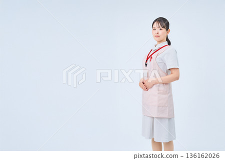 A young woman wearing a white coat and apron 136162026