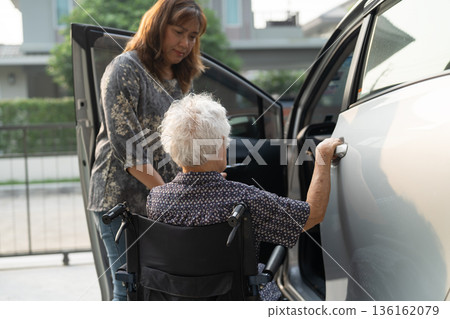 Caregiver help Asian elderly woman disability patient get in her car. Caregiver help Asian elderly woman disability patient get in her car. 136162079