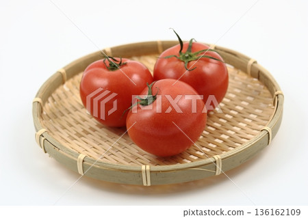 Three large, ripe tomatoes placed on a Japanese bamboo colander 136162109