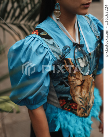 Stylish woman showcasing layered accessories in lush greenhouse setting 136162224