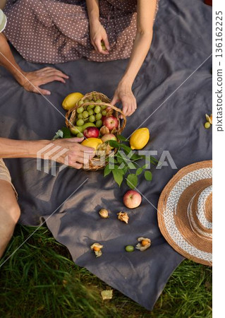 Person choosing and preparing fruits for cooking outdoors in sunlight 136162225
