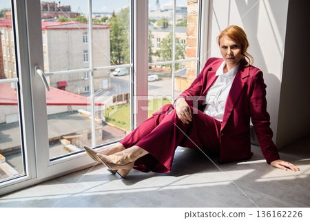 Elegant woman in deep thought observing lively city underneath sunlight Elegant woman in deep thought observing lively city underneath sunlight 136162226