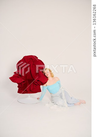 Stylish woman in contemporary outfit with artistic chair 136162268