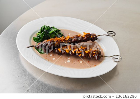 Indulgent grilled meat skewers with nuts and caramelized sauce 136162286