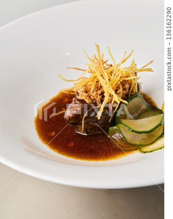 Closeup of tender braised meat with crispy garnish and cucumber 136162290