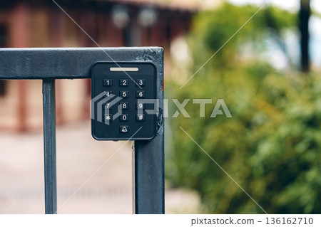 Keypad access control on a metal gate outside a building in a residential area Keypad access control on a metal gate outside a building in a residential area 136162710