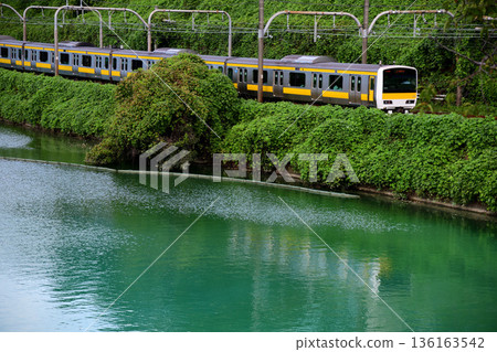 一列中央線列車沿著翠綠的外護城河行駛 136163542