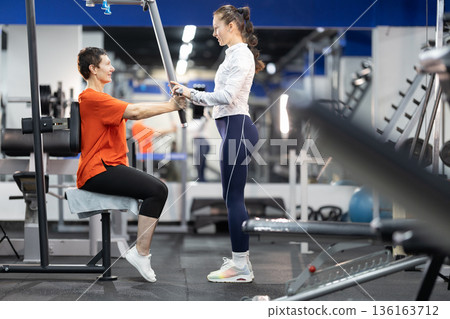 Senior woman training with personal gym coach 136163712