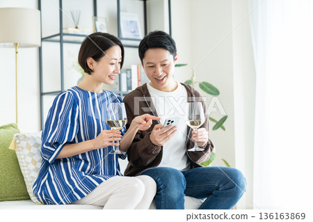 Middle-aged couple drinking wine in the living room Middle-aged couple drinking wine in the living room 136163869