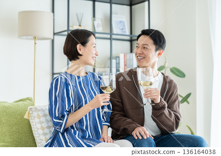 Middle-aged couple drinking wine in the living room Middle-aged couple drinking wine in the living room 136164038