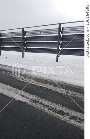 Snow fences installed on the side of the road to protect against blowing snow 136164295
