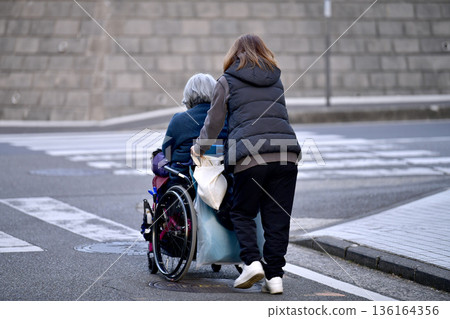 Yokohama cityscape in Japan: Steps and unevenness... Aging society: Elderly woman in wheelchair (no markings) has a hard time pushing... = Yokohama city Yokohama cityscape in Japan: Steps and unevenness... Aging society: Elderly woman in wheelchair (no markings) has a hard time pushing... = Yokohama city 136164356