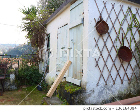 Wooden structure painted white in backyard garden. Barn and Mediterranean nature, Italy. Traditional old building.  136164394
