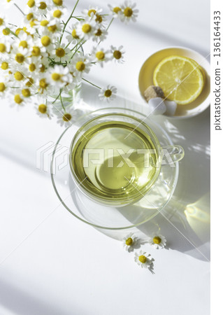 Tea time with matricaria and herbal tea (white background, overhead view) 136164433