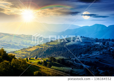 mountainous countryside landscape with rolling hills on summer solstice. day and night time change concept. rural area with sun and moon at twilight. beautiful view for equality and shift template 136164552