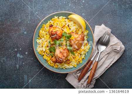 Traditional Indian dish chicken biryani with cilantro and lemon in a bowl top view on rustic background Traditional Indian dish chicken biryani with cilantro and lemon in a bowl top view on rustic background 136164619