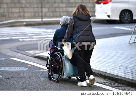 Yokohama cityscape in Japan: Steps and unevenness... Aging society: Elderly woman in wheelchair (no markings) has a hard time pushing... = Yokohama city Yokohama cityscape in Japan: Steps and unevenness... Aging society: Elderly woman in wheelchair (no markings) has a hard time pushing... = Yokohama city 136164645
