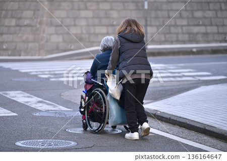 Yokohama cityscape in Japan: Steps and unevenness... Aging society: Elderly woman in wheelchair (no markings) has a hard time pushing... = Yokohama city 136164647