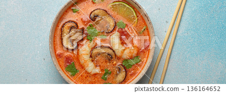 Tom yum soup with shrimp and mushrooms in bowl with chopsticks top view, traditional Thai soup 136164652