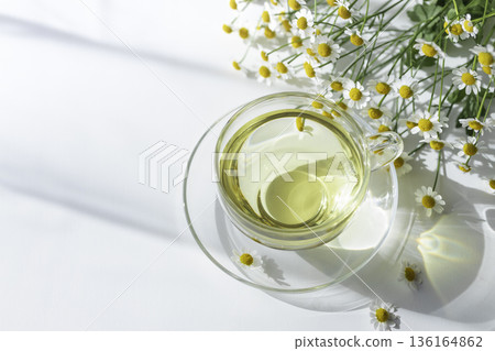 Natural light and shadows: Flat lay of matricaria and a transparent teacup Natural light and shadows: Flat lay of matricaria and a transparent teacup 136164862
