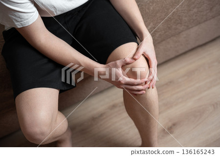 man holding his knee, knee pain 136165243