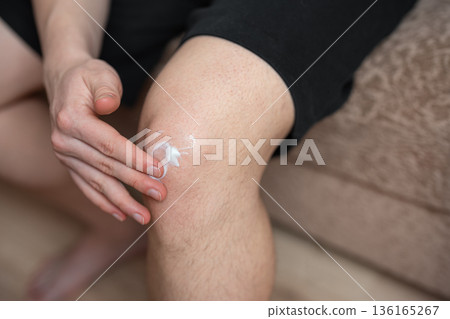 man applying ointment cream on  his knee, knee pain 136165267