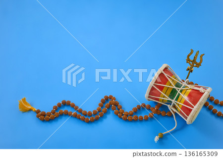 Maha Shivratri. Shiva symbols damaru and rudraksha mala on blue Maha Shivratri. Shiva symbols damaru and rudraksha mala on blue 136165309