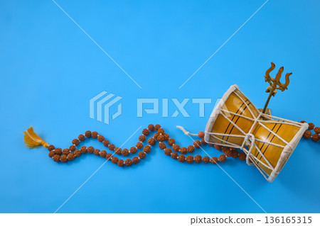 Maha Shivratri. Lord shiva symbols with damaru, trishula, rudraksha mala on blue Maha Shivratri. Lord shiva symbols with damaru, trishula, rudraksha mala on blue 136165315
