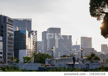 Office buildings and a stone bridge in the park at dusk Office buildings and a stone bridge in the park at dusk 136165326