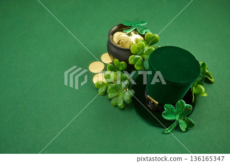 Leprechaun hat, pot of gold, shamrocks on green background 136165347