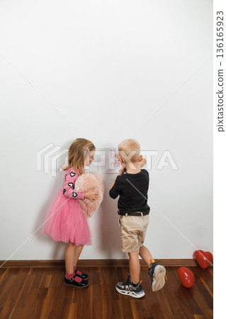 Children play and learn together at a party in a bright room with decorations and balloons Children play and learn together at a party in a bright room with decorations and balloons 136165923