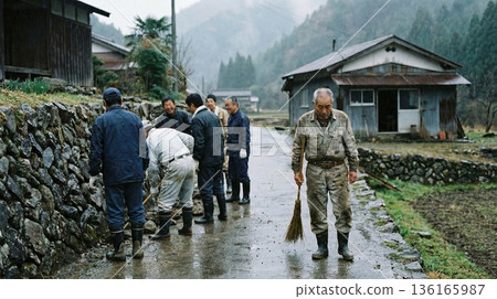 一位老人在雨中打掃衛生,村民們在他身後聊天,對他視而不見。 一位老人在雨中打掃衛生,村民們在他身後聊天,對他視而不見。 136165987