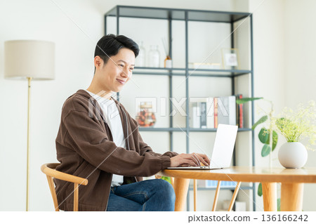Middle-aged man using a computer at home Middle-aged man using a computer at home 136166242