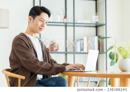 Middle-aged man using a computer at home Middle-aged man using a computer at home 136166243