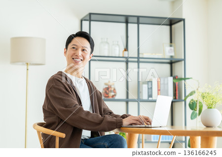 Middle-aged man using a computer at home Middle-aged man using a computer at home 136166245