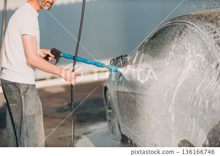 Worker washing car at self-service car wash Worker washing car at self-service car wash 136166746