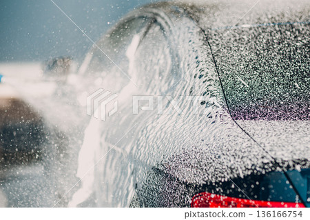 Worker washing car at self-service car wash 136166754