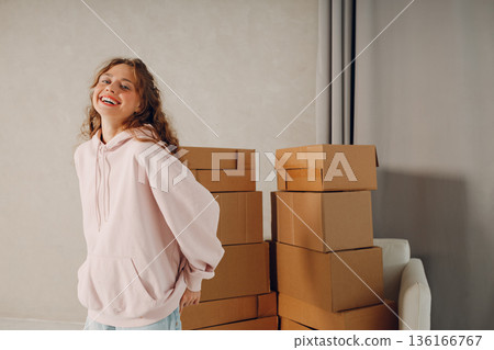 Happy young woman portrait moving with cardboard boxes to new estate home apartment 136166767