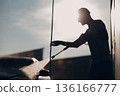 Worker man silhouette washing car at self service car wash 136166777
