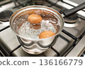 Saucepan stainless steel with boiling eggs breakfast in water on gas stove. 136166779