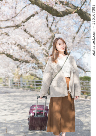 Young woman walking along cherry blossom trees Young woman walking along cherry blossom trees 136167092