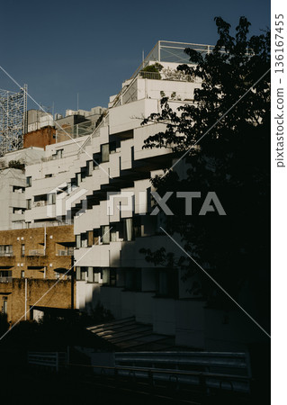 Terraced apartment buildings and shadows illuminated by evening light 136167455