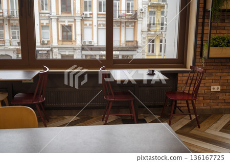 A cozy restaurant interior with tables for a quick lunch, large windows overlooking the old town A cozy restaurant interior with tables for a quick lunch, large windows overlooking the old town 136167725