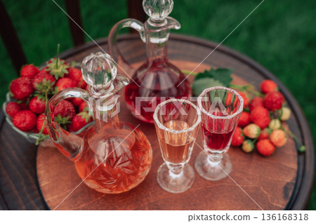 Strawberry Liqueur in Elegant Glass Decanters Outdoors Strawberry Liqueur in Elegant Glass Decanters Outdoors 136168318